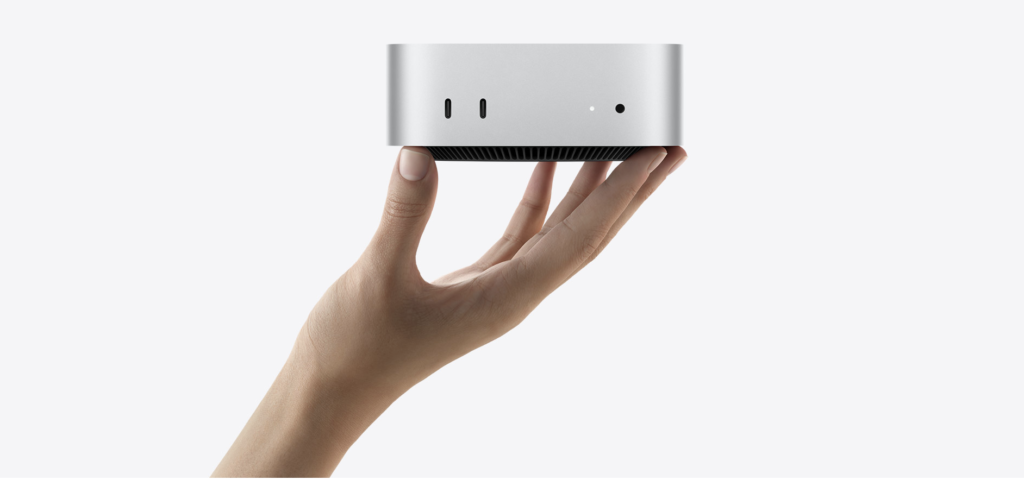 Mac mini compacto sobre mesa de trabalho, sugerindo desktop para desenvolvimento e produtividade